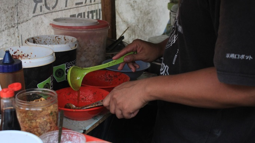 A’ Onong mengolah mie pedas, adonan wonton, dan saus khas racikannya. (Foto: Ayu Tria Handayani)