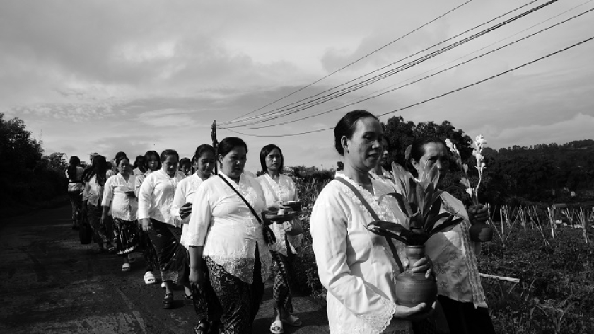 Ibu-ibu membawa sesaji saat arak-arakan menuju mata air sebagai ungkapan terima kasih di perayaan Tahun Baru Kalender Sunda ke-1959, di Cicalung, 1 Juli 2025. (Foto: Fitri Amanda/BandungBergerak)