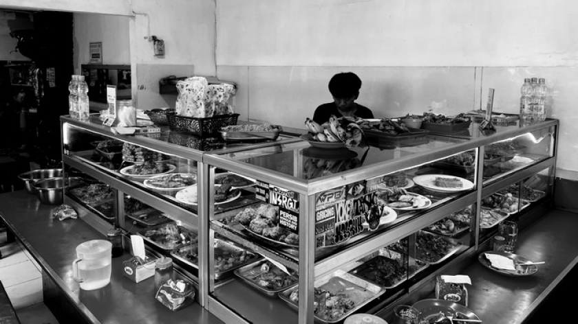 Pedagang warteg di Bandung membungkus nasi, Rabu, 10 Juni 2026. Pelemahan rupiah berdampak pada pedagang kecil. (Foto: Yopi Muharam/BandungBergerak)