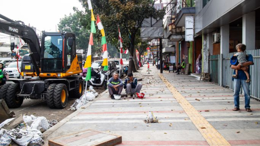 Petugas beristirahat setelah membersihkan sampah dari saluran drainase di kawasan Cicadas, Bandung. Pembersihan dilakukan setelah penertiban sejumlah aktivitas PKL, 21 Agustus 2026. (Foto: Insan Radhiyan/BandungBergerak)