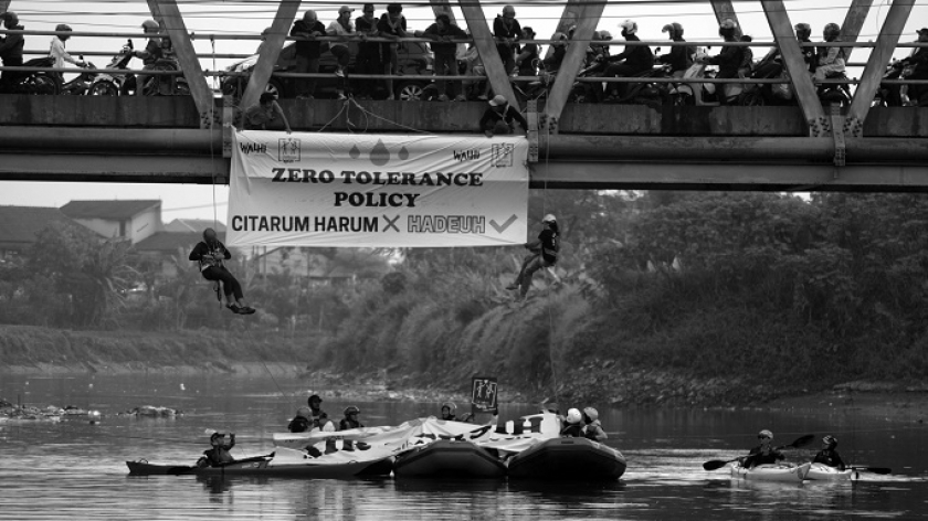 Aktivis lingkungan dari Walhi Jabar melakukan kampanye zero tolerance policy terkait program Citarum Harum di bawah jembatan Sungai Citarum di Baleendah, Kabupaten Bandung, 19 Mei 2024. (Foto: Prima Mulia/BandungBergerak)