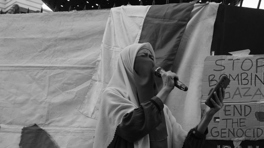 Pembacaan puisi oleh perwakilan Komunitas Celah-Celah Langit Elly Dzarrah dalam aksi Asia Afrika Berkabung Pestipal, Bandung, 14 Juli 2024. (Foto: Audrey Kayla F/BandungBergerak)