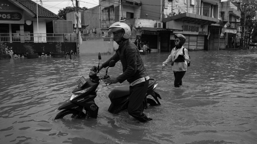 Warga mendorong sepeda motornya yang mogok saat banjir menerjang kawasan Dayeuhkolot, Kabupaten Bandung, 11 September 2024. (Foto: Prima Mulia/BandungBergerak)