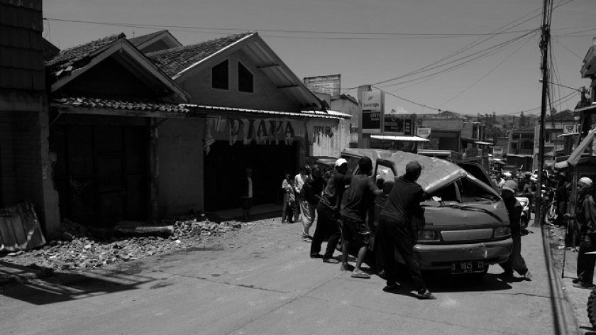 Warga mendorong mobil rusak tertimpa bangunan roboh di Desa Cibeureum pascagempa magnitudo 4,9 mengguncang Kecamatan Kertasari, Kabupaten Bandung, 18 September 2024. (Foto: Prima Mulia/BandungBergerak)