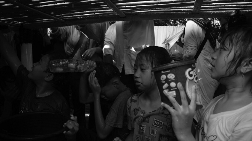 Anak-anak menunggu cucuran air cucian gamelan pusaka saat prosesi Ngarumat Pusaka di Bumi Alit Kabuyutan Batukarut Lebakwangi di Arjasari, Kabupaten Bandung, 16 September 2024. (Foto: Prima Mulia/BandungBergerak)