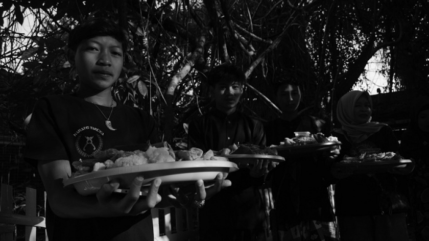 Anak-anak muda membawa hantaran ke rumah adat saat prosesi Ngarumat Pusaka di Bumi Alit Kabuyutan Batukarut Lebakwangi di Arjasari, Kabupaten Bandung, 16 September 2024. (Foto: Prima Mulia/BandungBergerak)