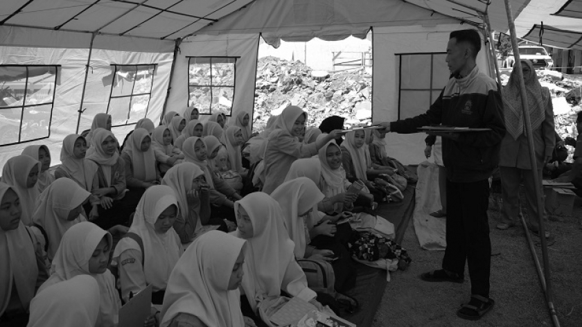 Murid SMP Muhammadiyah 3 mendapat alat-alat tulis bantuan dari donatur saat sekolah hari pertama pascagempa di tenda darurat di Kampung Neglasari, Kecamatan Kertasari, Kabupaten Bandung, 30 September 2024. (Foto: Prima Mulia/BandungBergerak) 