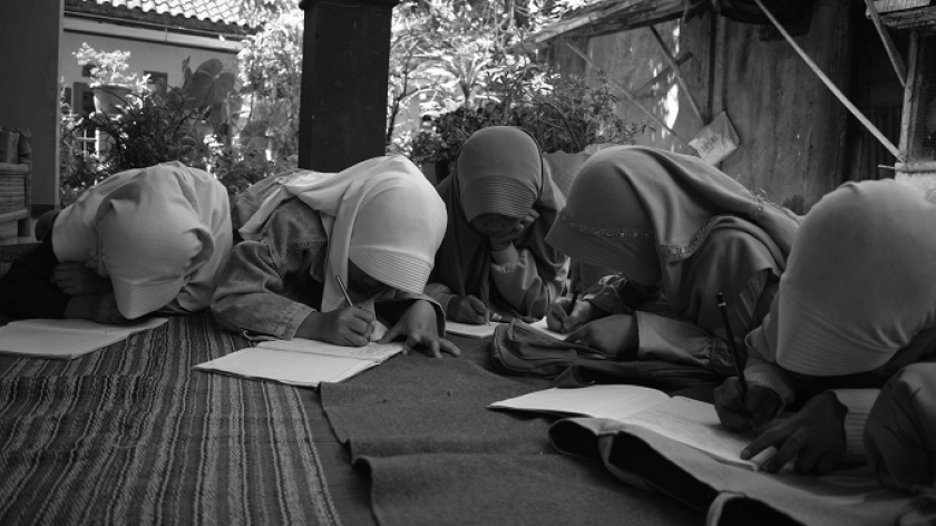 Santri madrasah ibtidaiyah Nurul Falah mengerjakan tugas saat sekolah untuk pertama kali pasca gempa di halaman rumah guru di Desa Cikembang, Kecamatan Kertasari, Kabupaten Bandung, 30 September 2024. (Foto: Prima Mulia/BandungBergerak) 