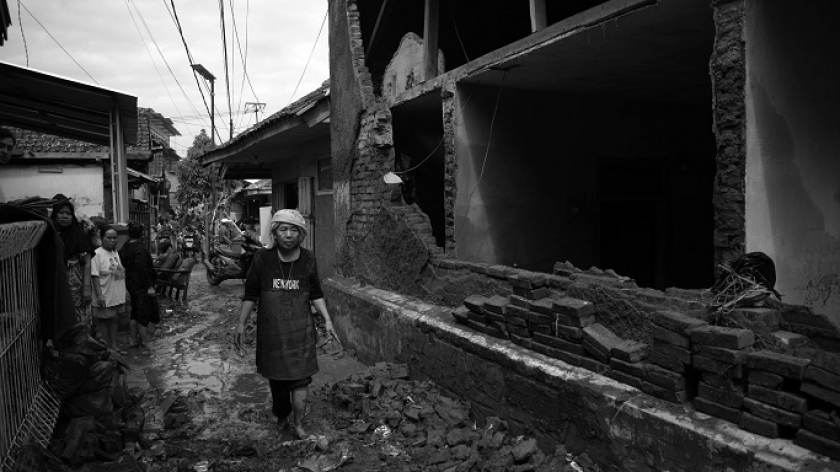 Warga melewati jalan kampung dan halaman rumah tertutup lumpur akibat banjir bandang di Desa Banjaran Wetan, Kecamatan Banjaran, Kabupaten Bandung, 6 November 2024. (Foto: Prima Mulia/BandungBergerak)