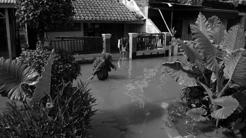 Warga berjalan menembus banjir di Kampung Bojongasih, Kecamatan Dayeuhkolot, Kabupaten Bandung, 21 November 2024. (Foto: Prima Mulia/BandungBergerak)