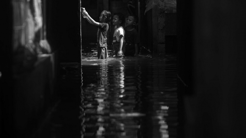 Anak-anak bermain air banjir di lorong gang Kampung Bojongasih, Kecamatan Dayeuhkolot, Kabupaten Bandung, 21 November 2024.  (Foto: Prima Mulia/BandungBergerak)