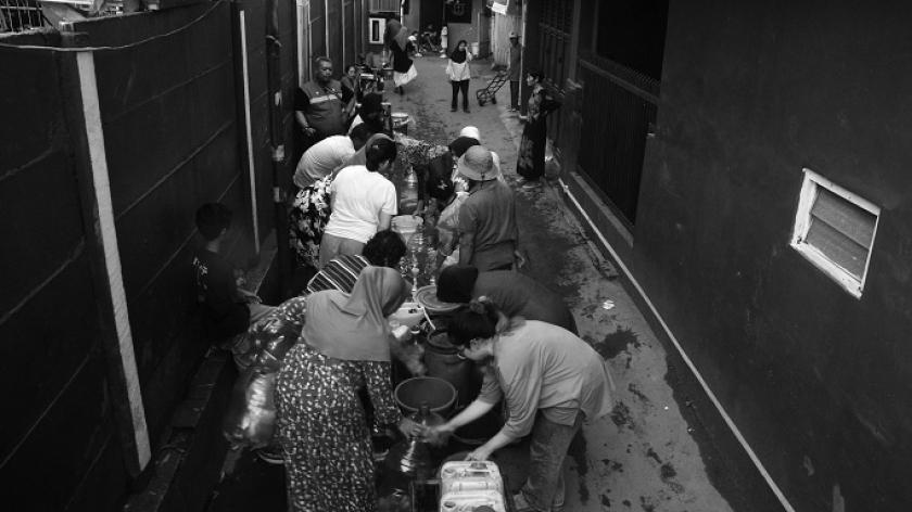 Antrean warga mengisi air bantuan PDAM ke jerigen dan botol galon di Mekarsari, Kelurahan Babakan Sari, Kecamatan Kiaracondong, Bandung, 5 Desember 2024. (Foto: Prima Mulia/BandungBergerak)