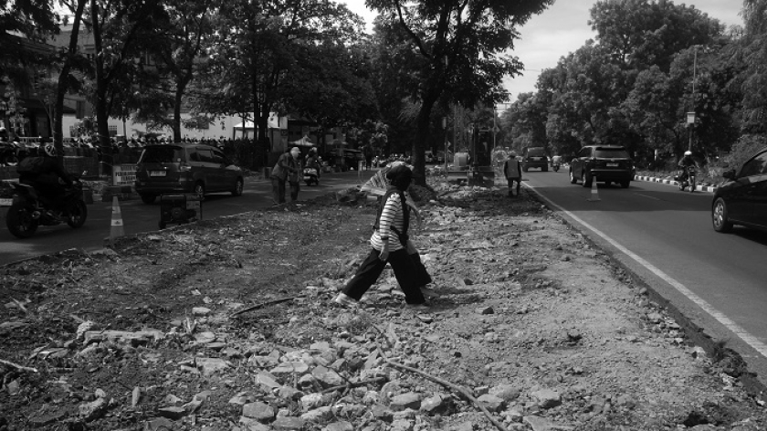 Warga melintas di proyek pembangunan trotoar di sepanjang jalur hijau Jalan Pahlawan, Kota Bandung, 23 Oktober 2024. (Foto: Prima Mulia/BandungBergerak)