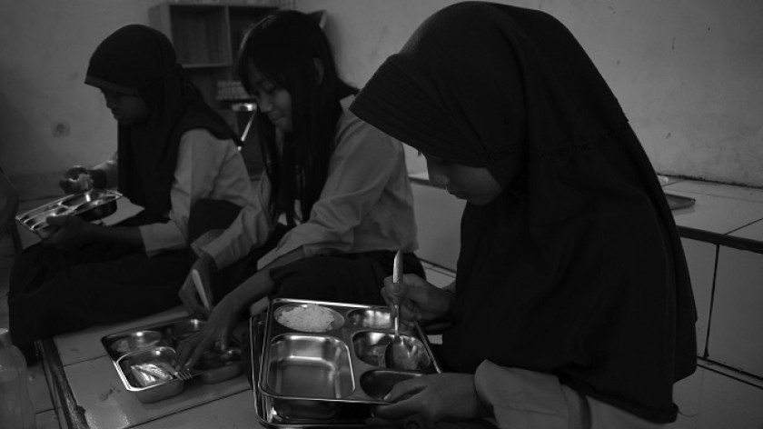 Murid SDN 013 Pasirkaliki, Kota Bandung, menyendok nasi program Makan Bergizi Gratis, 8 Januari 2025. (Foto: Prima Mulia/BandungBergerak)