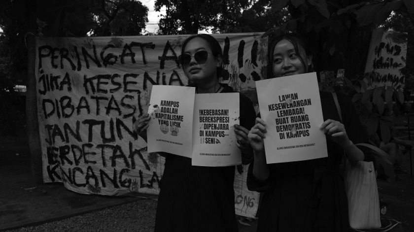 Mahasiswi membawa poster protes saat aksi unjuk rasa di taman kampus ISBI, Bandung, 17 Februari 2025. (Foto: Prima Mulia/BandungBergerak)