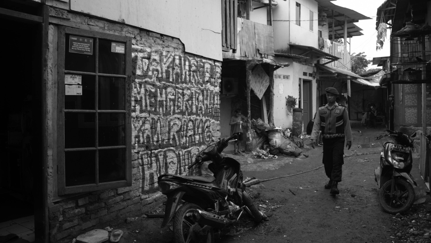 Petugas polisi berjalan di tengah lahan konflik Sukahaji. (Foto: Prima Mulia/BandungBergerak)