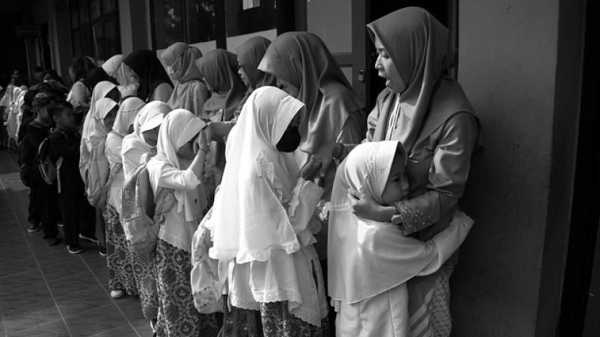 Murid-murid perempuan kelas 1 menyalami guru di hari pertama sekolah usai libur lebaran di SDN 025 Cikutra, Bandung, 2 Mei 2023. (Foto: Prima Mulia/BandungBergerak)