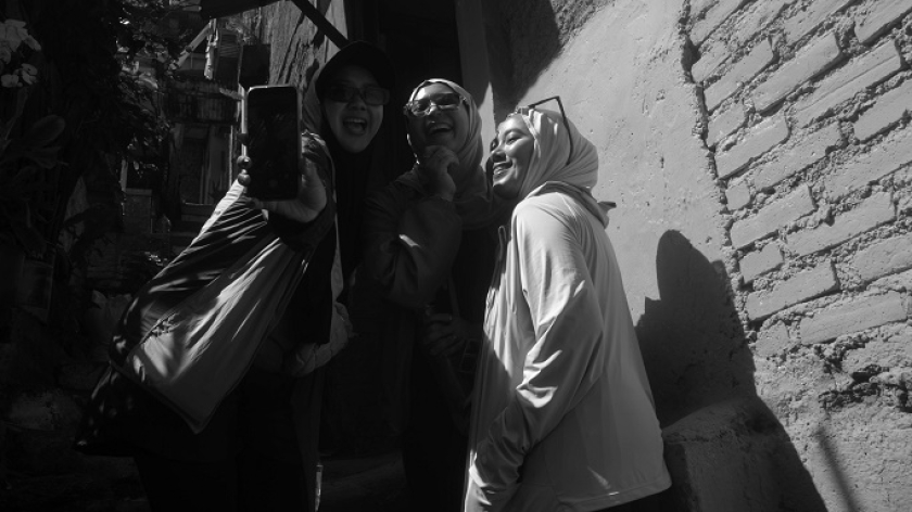 Warga berfoto saat susuri gang Lembur Katumbiri atau Kampung Pelangi atau Kampung 200 di lembah Manteos, 29 April 2025. (Foto: Prima Mulia/BandungBergerak) 