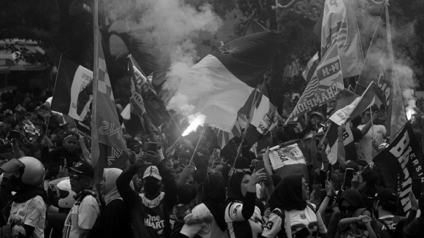 Bobotoh Persib Bandung membakar flare dan bom asap saat merayakan kemenangan Persib di BRI Liga 1 2024/2025 di Gedung Sate, Bandung, 25 Mei 2025. (Foto: Prima Mulia/BandungBergerak)