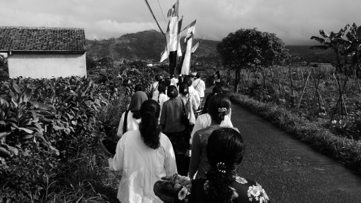 Sisi kiri dan kanan terdapat perkebunan warga yang mengiringi langkah arak-arakan Tahun Baru Kalender Sunda di Cicalung, Selasa, 1 Juli 2025. (Foto: Fitri Amanda/BandungBergerak)