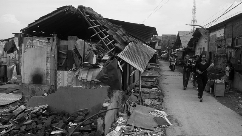 Warga berjalan melewati rumah-rumah roboh di Kampung Sukahaji, 17 Juni 2025. (Foto: Prima Mulia/BandungBergerak)