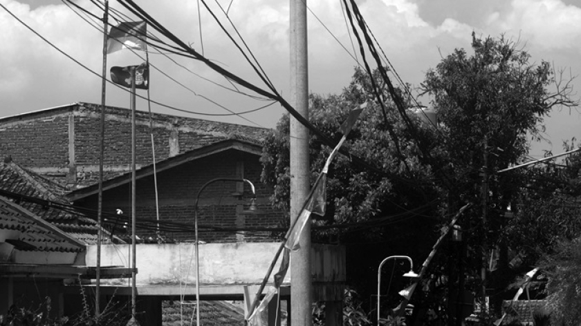 Bendera Jolly Roger dari serial anime Jepang One Piece di antara umbul-umbul dan bendera Merah Putih  terlihat di sebuah permukiman di Bandung, Jawa Barat, 3 Agustus 2025. (Foto: Prima Mulia/BandungBergerak.id) 