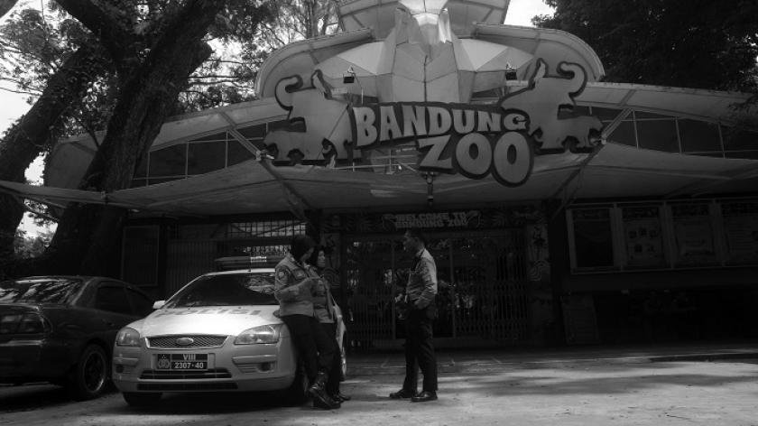 Polisi berjaga di gerbang saat Bandung Zoo atau Kebun Binatang Bandung tutup karena dampak dari konflik dualisme manajemen di Bandung, 3 Juli 2025. (Foto: Prima Mulia/BandungBergerak)