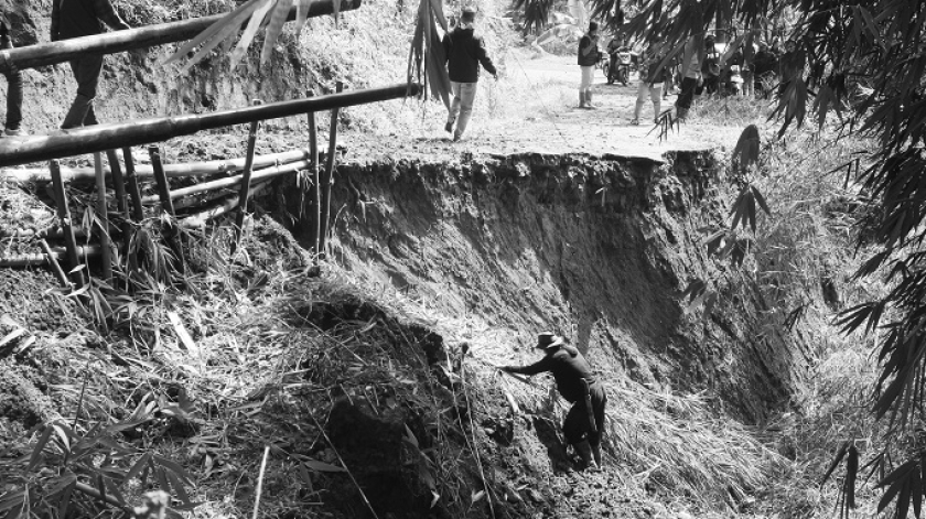 Petugas memperluas jalan dan menambal jalan dengan bambu beserta tanah merah di jalan yang terputus di area  penghubung Desa Ciririp dan Desa Bangsaya, 5 Desember 2025. (Foto: Insan Radhiyan/BandungBergerak)