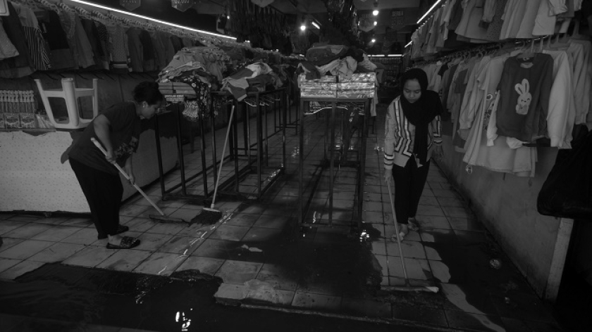 Warga membersihkan toko setelah terdampak terencam banjir di Bandung Selatan, 5 Desember 2025. (Foto: Prima Mulia/BandungBergerak)