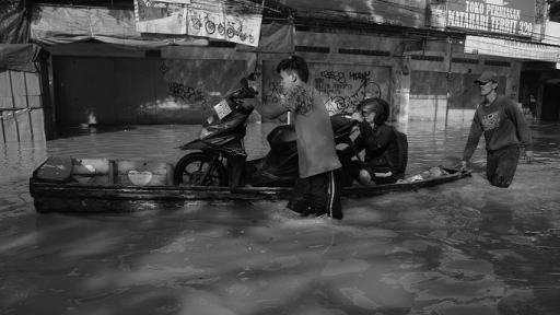 Warga berjalan menembus banjir Sungai Citarum di Jalan Raya Dayeuhkolot, Kecamatan Dayeuhkolot, Kabupaten Bandung, Jawa Barat, 16 Maret 2025. (Foto: Prima Mulia/BandungBergerak)