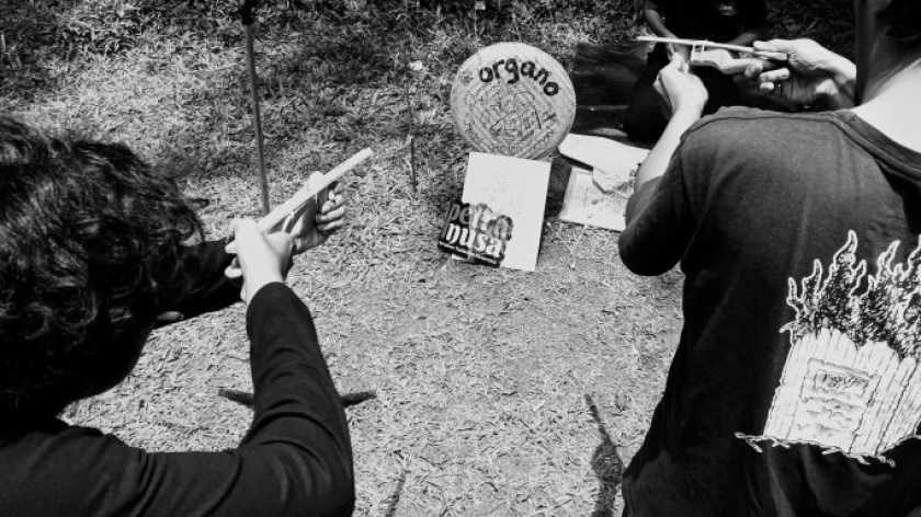 Peserta Pangan Centils menembakan bedil karet ke papan kayu di Kama Karsa Dago Pakar, Bandung, Minggu, 1 Februari 2025. (Foto: Insan Radhyan/BandungBergerak)