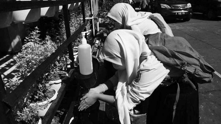 Anak-anak SMP Pasundan 1 menjalankan protokol cuci tangan sebelum mengikuti simulasi pelaksanaan belajar tatap muka di Bandung, Senin (7/6/2021). (Foto: Prima Mulia/BandungBergerak.id)