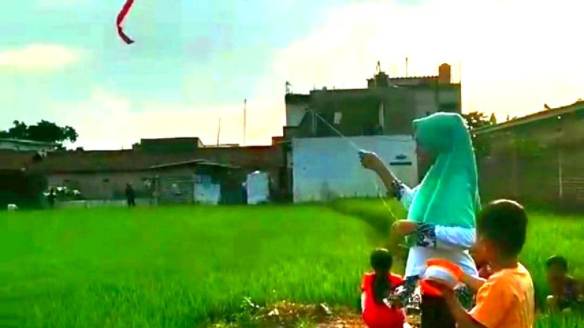Kaka Fia, Aa Akil bersama temannya asyik bermain layang-layang di sawah, Babakan Dangdeur, Pasirbiru, Selasa, 22 Februari 2022. (Foto: Ibn Ghifarie/BandungBergerak) 
