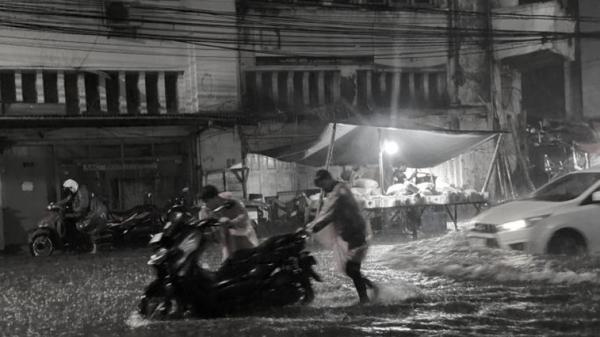 Hujan turun deras membuat pengendara mendorong motornya yang terjebak banjir, Pasar Andir, Bandung, Sabtu, 11 April 2026. (Foto: Yopi Muharam/BandungBergerak)