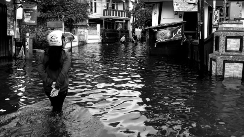Warga berjalan di jalan yang tergenang banjir, Kabupaten Bandung,  Jumat, 17 April 2026. (Foto: Muhammad Akmal/BandungBergerak)