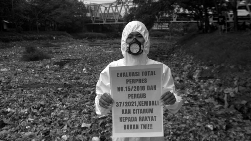 Aktivis mengusung poster di atas hamparan sampah yang menutupi permukaan Sungai Citarum di Oxbow Bojongsoang, Kabupaten Bandung, 22 Mei 2026. (Foto: Prima Mulia/BandungBergerak)
