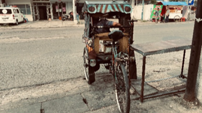 Pak Sawi sedang menunggu penumpang di kawasan Pasar Sayati. (Foto: Dokumentasi Widya Putri Pramesti)