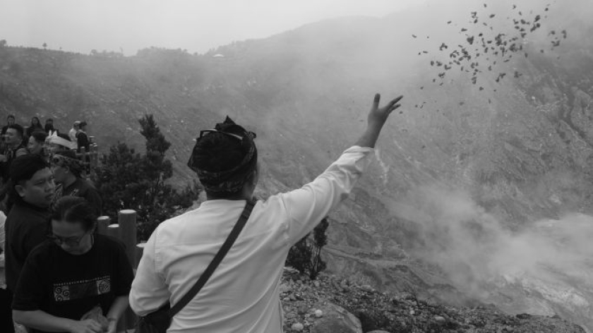 Melempar sesaji di ritual Ngertakeun Bumi Lamba, upacara untuk menjaga keharmonisan alam di kaki Gunung Tangkuban Parahu, Kabupaten Bandung Barat, Minggu, 21 Juni 2026. (Foto: Prima Mulia/BandungBergerak)
