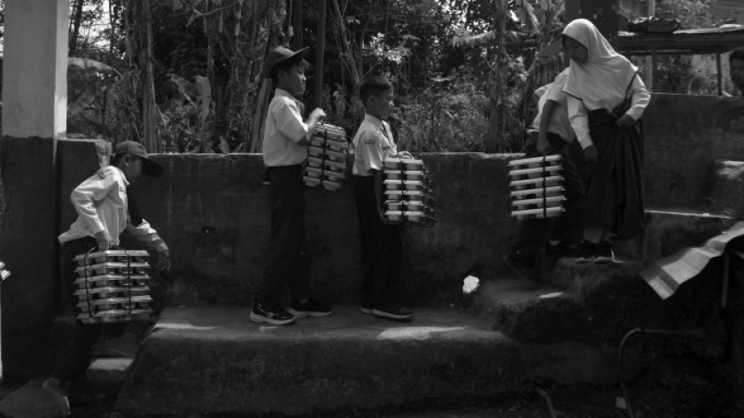 Murid membawa ompreng MBG di halaman SDN Girimukti, Kampung Rajamandala, Desa Mandalamukti, Kecamatan Cikalong Wetan, Kabupaten Bandung Barat, Senin, 27 Juli 2026. (Foto: Prima Muli