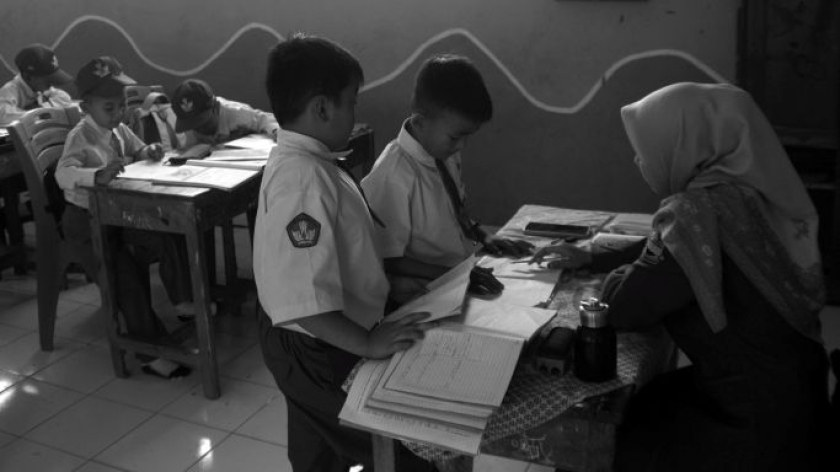 Guru memeriksa tugas murid SDN Girimukti, Kampung Rajamandala, Desa Mandalamukti, Kecamatan Cikalong Wetan, Kabupaten Bandung Barat, Senin, 27 Juli 2026. (Foto: Prima Mulia/BandungBergerak)
