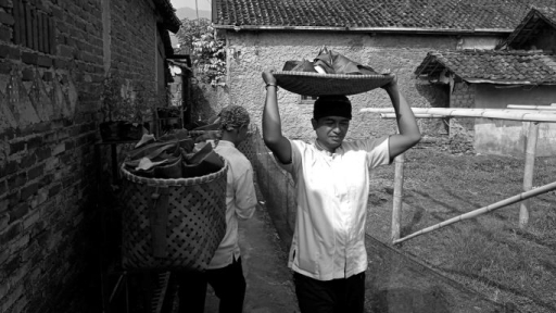 Mengantar hantaran makanan ke rumah-rumah warga sebagai bagian dari tradisi berbagi dalam Wuku Taun, Juli 2026. (Foto: Prima Mulia/BandungBergerak)
