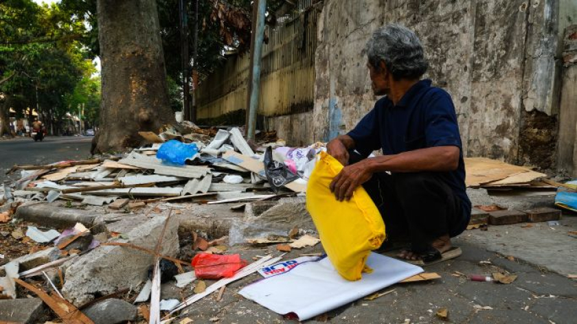 Seorang pedagang mengumpulkan barang setelah penggusuran PKL di Jalan Rajawali Timur, Kota Bandung. Kamis, 13 Agustus 2026.  (Foto: Alya Chaerani/BandungBergerak)