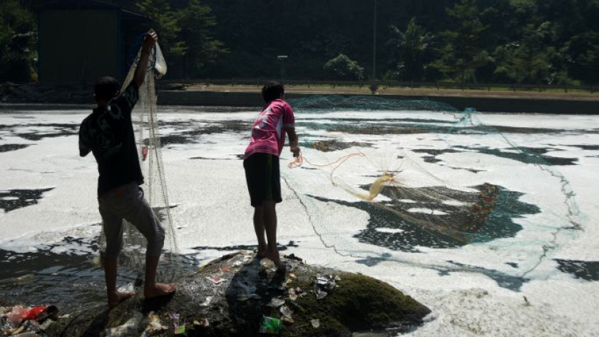Menjaring ikan di air limbah di Sungai Citarum, Margaasih, Kabupaten Bandung, Sabtu, 5 Juli 2026.  (Foto: Prima Mulia/BandungBergerak)
