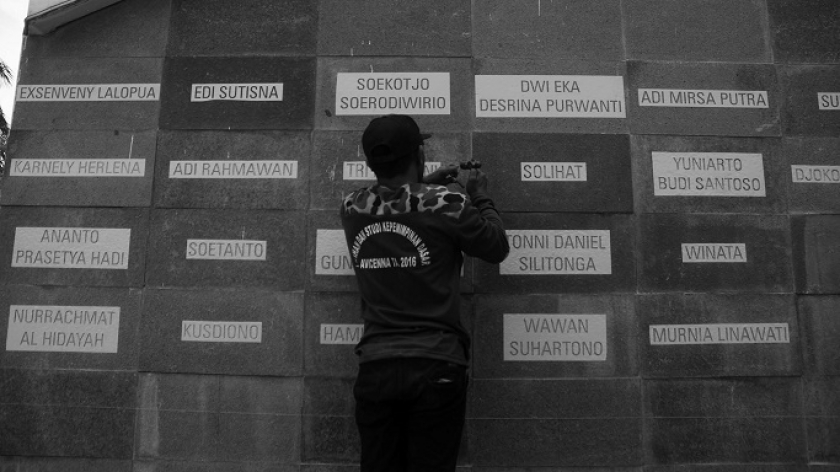 Pekerja memahat nama-nama nakes yang gugur di monumen perjuangan pahlawan Covid-19, kawasan Gasibu, Bandung, Jumat (2/10/2021). (Foto: Prima Mulia/BandungBergerak.id) 