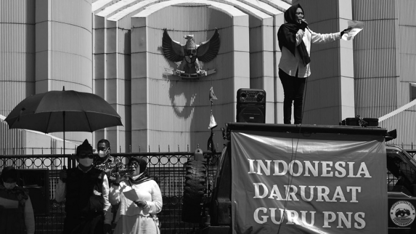 Seorang guru honorer membacakan puisi di Monumen Perjuangan Rakyat Jawa Barat di Bandung, Kamis (25/11/2021). Guru dari sejumlah forum guru honorer menuntut pemerintah segera mengangkat guru PNS. (Foto: Prima Mulia/BandungBergerak.id)