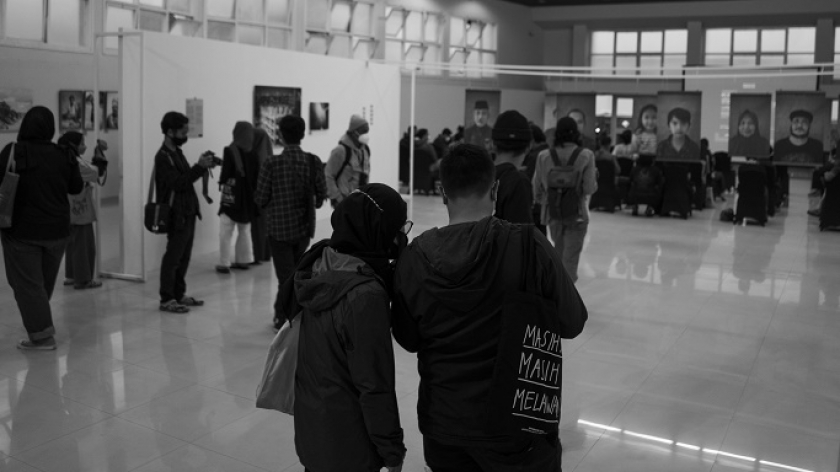 Pengunjung menikmati Pameran Foto Kisah Senyap yang diselenggarakan oleh PannaFoto Institute bekerjasama dengan Universitas Katolik Parhyangan (Unpar) di Aula Unpar, Jalan Merdeka, Bandung, Jumat (4/2/2022). (Foto: Virliya Putricantika/BandungBergerak.id)