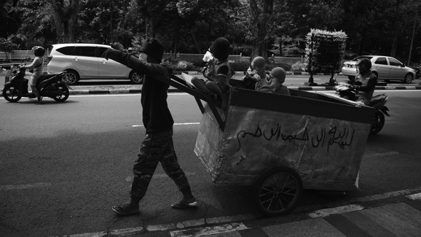 Warga tunawisma bersama anaknya di atas gerobak melintasi jalanan di Bandung, Jawa Barat, Jumat (29/10/2021). Kaum marjinal seperti ini dipastikan luput dari pendataan penerima bantuan sosial pemerintah saat pandemi Covid-19. (Foto: Prima Mulia/BandungBergerak.id)