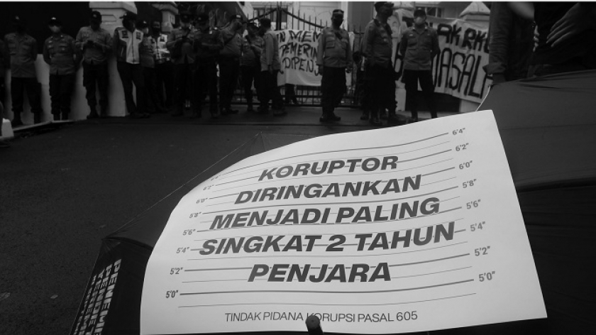 Massa aksi memegang poster saat unjuk rasa menentang pengesahan RKUHP di depan gedung DPRD Jawa Barat di Bandung, Selasa, 6 Desember 2022. Mereka menuntut pemerintah merevisi sejumlah pasal di RKUHP yang mengancam kebebasan berpendapat masyarakat sipil dengan hukuman penjara. (Foto: Prima Mulia/BandungBergerak.id)