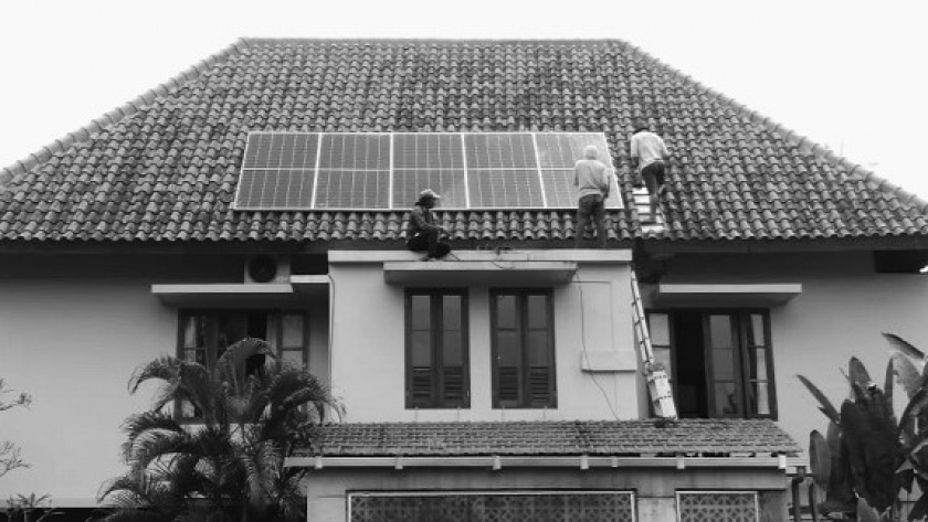 Pekerja sedang memasang panel surya di atap rumah. (Foto: Dokumentasi Gung Kayon)