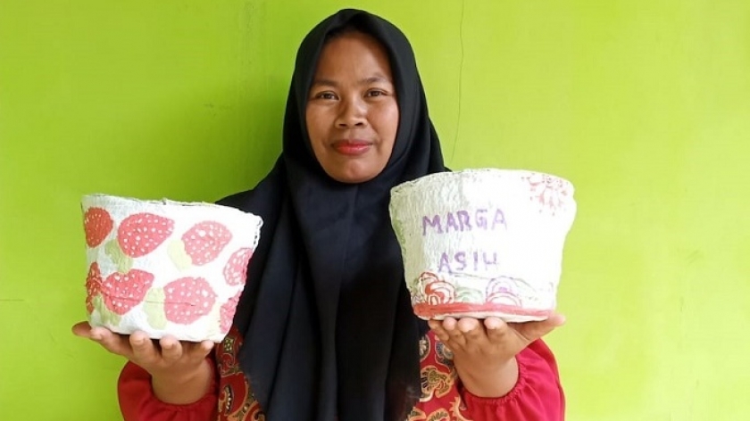 Pipih (43), warga Cicalengka, berfoto dengan pot tanaman yang terbuat dari limbah popok bayi. (Sumber Foto: Laelatul Azizah)